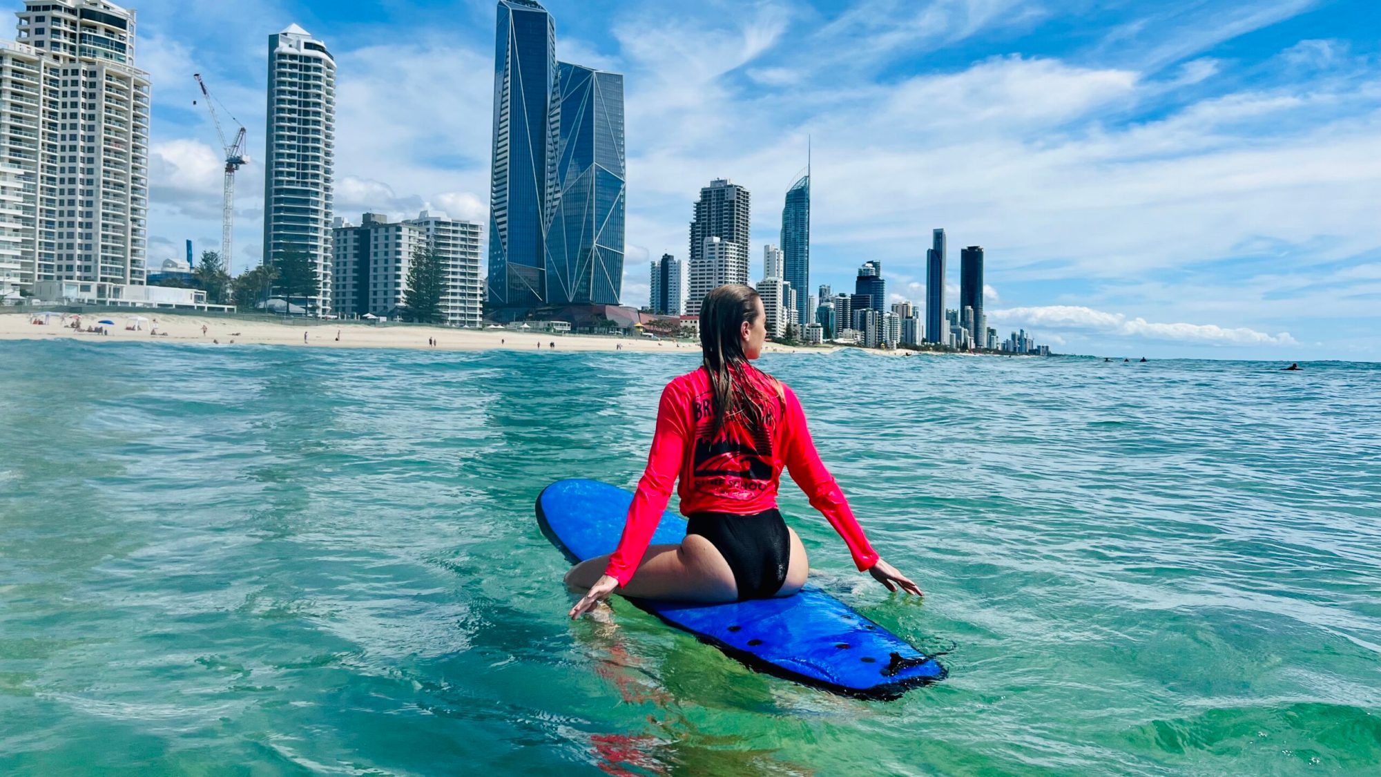 a young girl riding a wave on top of a body of water